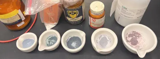 Mortars containing butterfly pea flowers ground together with various colorless solids